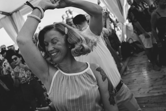 Una mujer sonriente baila alegremente mientras otra persona la acompaña.